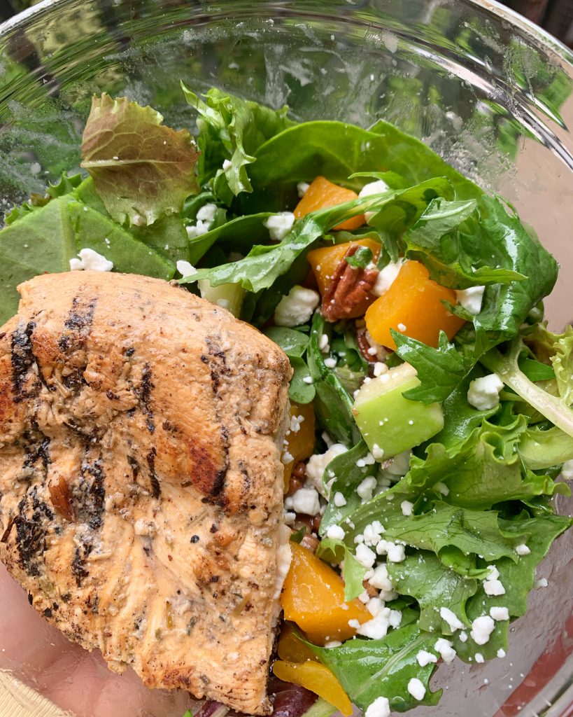 Grilled chicken on a bed of greens with goat cheese, diced apple, pecans, and butternut squash.